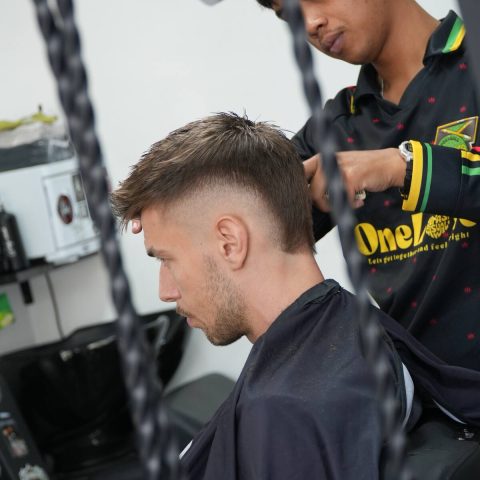 Barber working on a fade at SAE Collective Studio