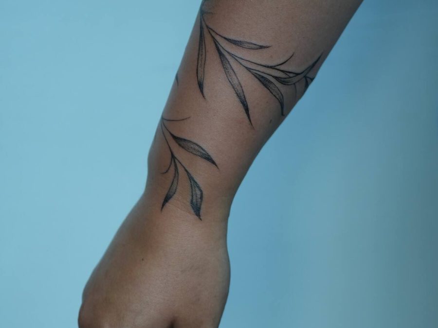 Fine line vine tattoo running down an arm