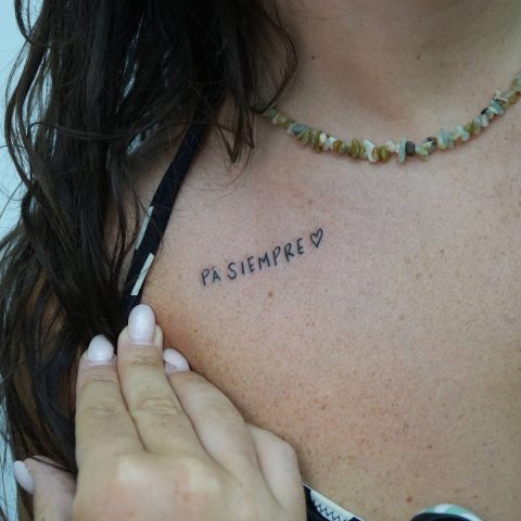 Delicate script lettering on a collarbone