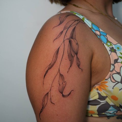Fine line leaves trailing over a shoulder