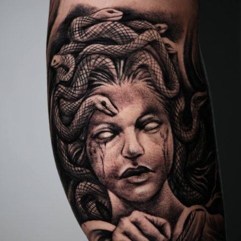 Close up of a detailed black and grey forearm tattoo